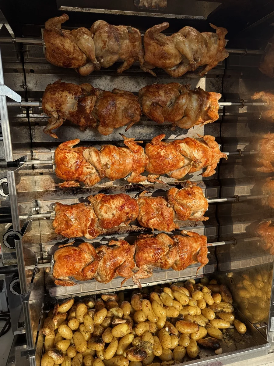 Trufflehunters rotisserie chickens cooking on the spit at a Yorkshire outdoor event